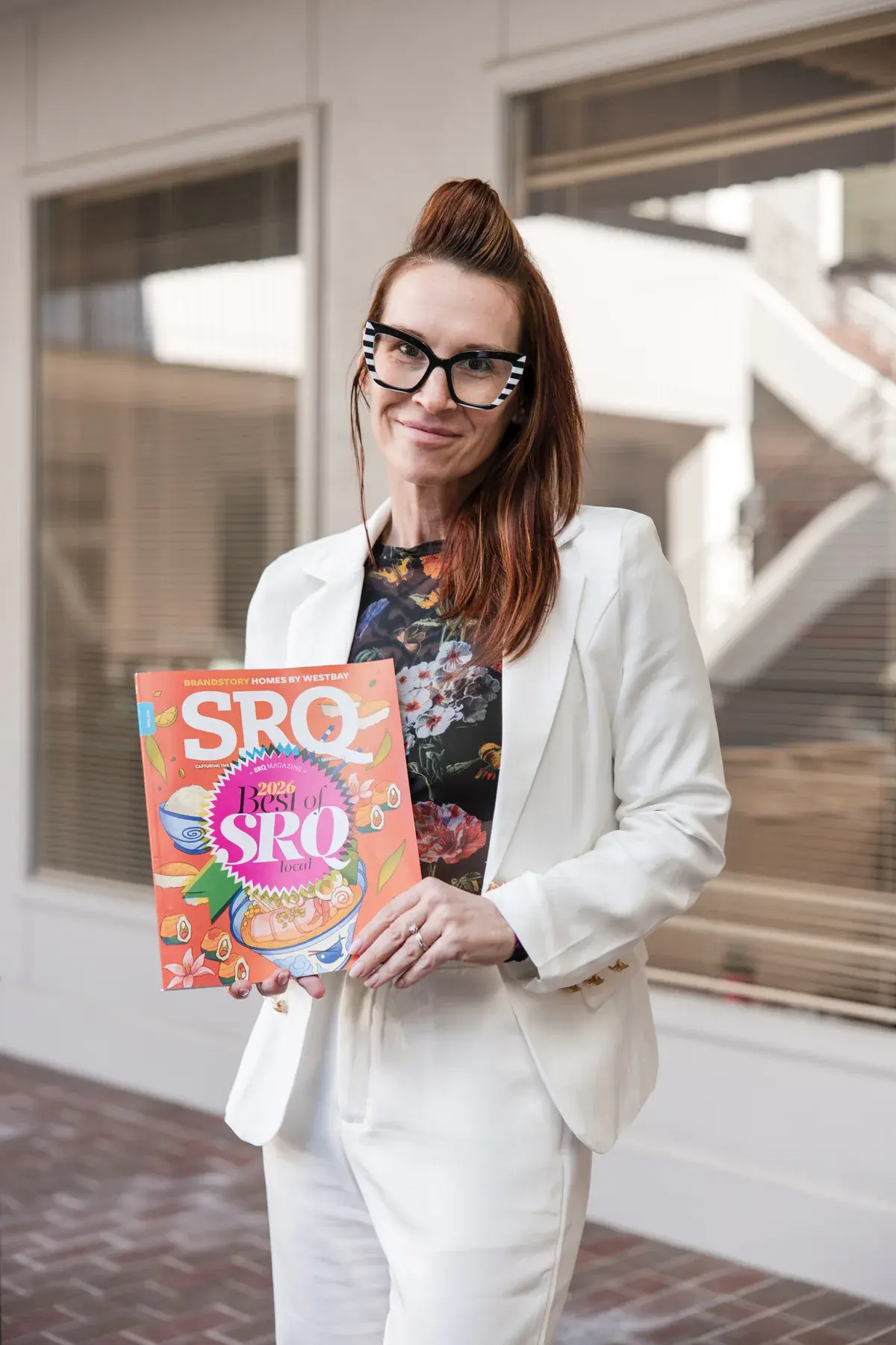 Dr. Sarah Secor-Jones holding an issue of SRQ magazine