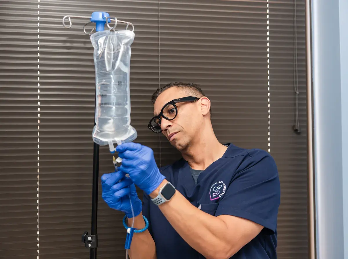 Charles, RN preparing an IV fluid bag at Lesh Lifestyle